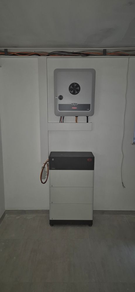 Wechselrichter von Fronius an der Wand montiert, Speicher von BYD darunter. Etwas Kabelkanal und Leitungen