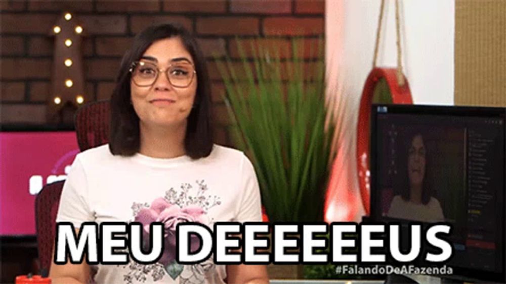 a woman sitting in front of a computer with the words meu deeeeeus written on her shirt