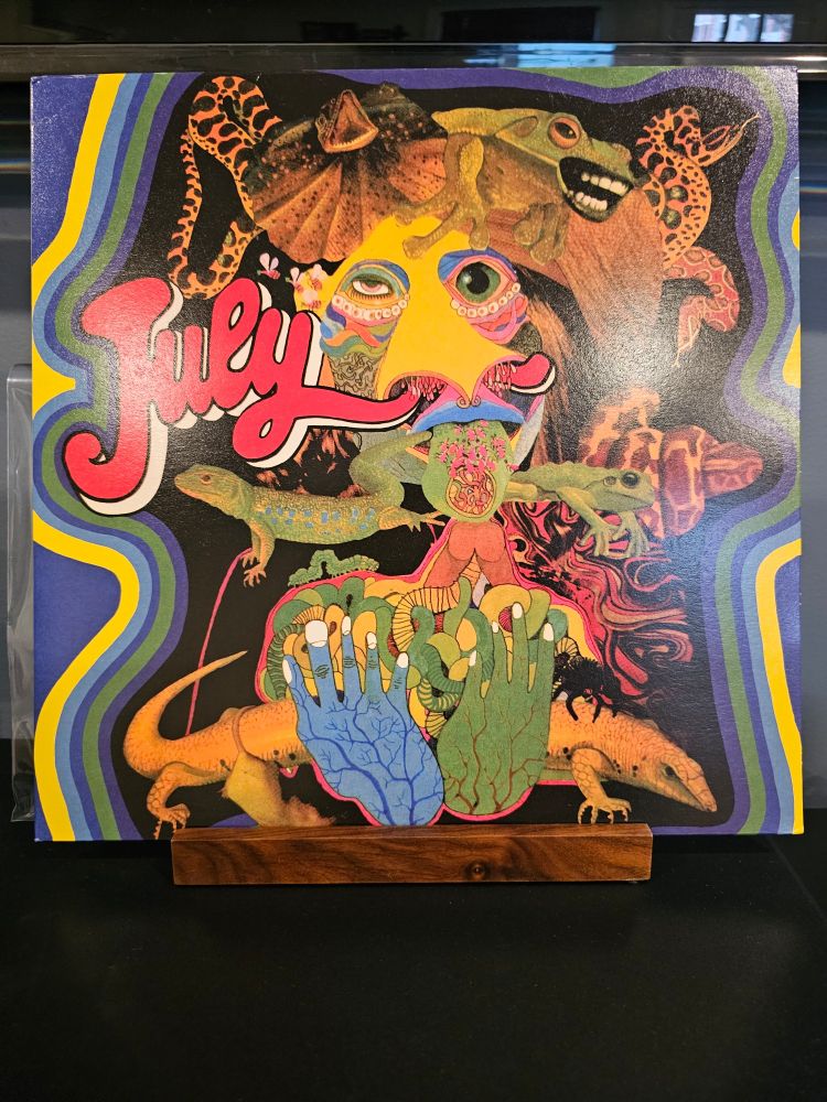 The front cover for July by July, featuring psychedelic looking reptiles.