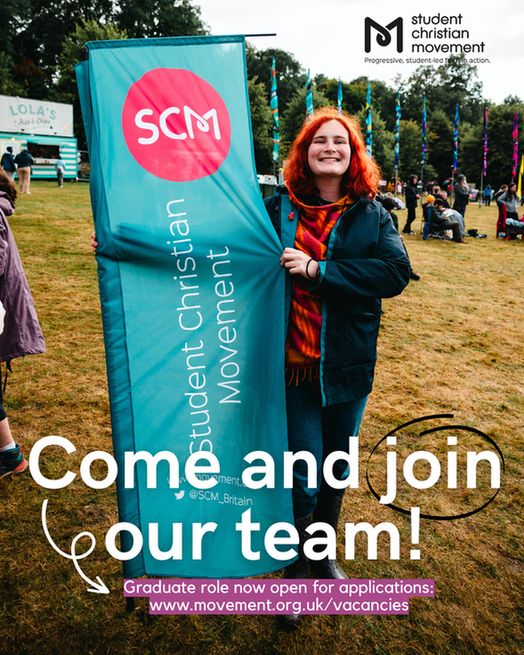 A photo of staff member Phoebe at Greenbelt last year holding an SCM banner and smiling at the camera.