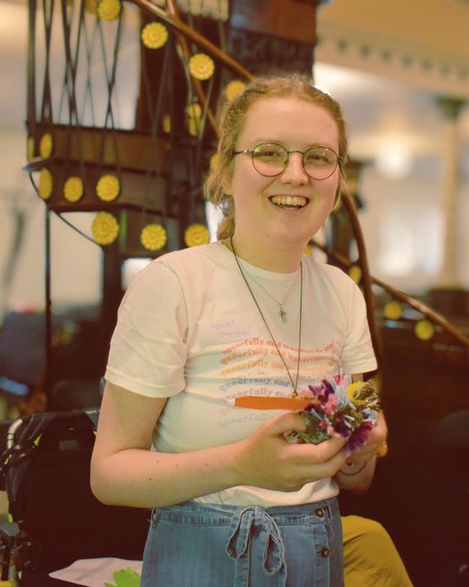 An SCM member stands with one of the craft creations from the day, a yarn sparrow.