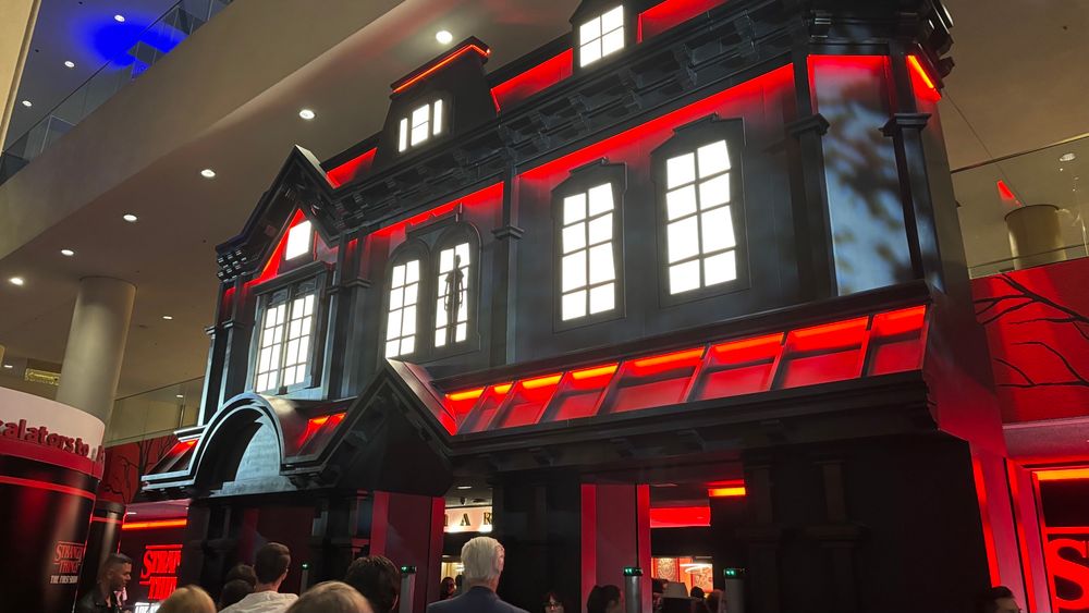 Creepy red neon mansion set up in theatre lobby