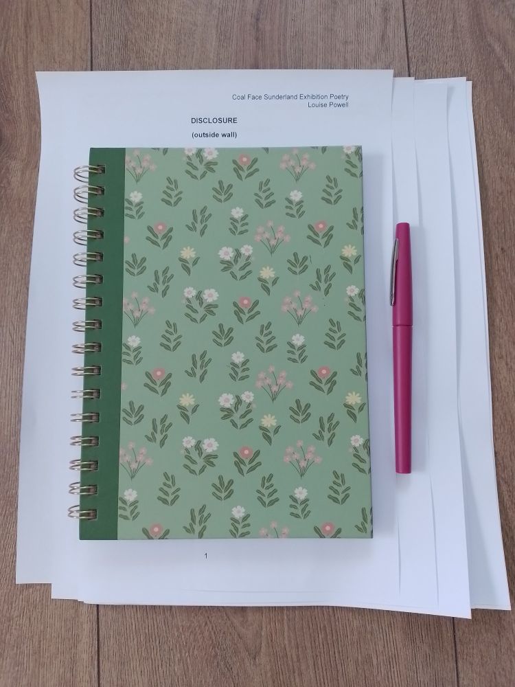 A pile of papers, the header of which reads 'Coal Face Sunderland Exhibition Poetry'. There is a title: DISCLOSURE (outside wall).
Over the paper is a green notebook patterned with flowers and a cerise pen.
