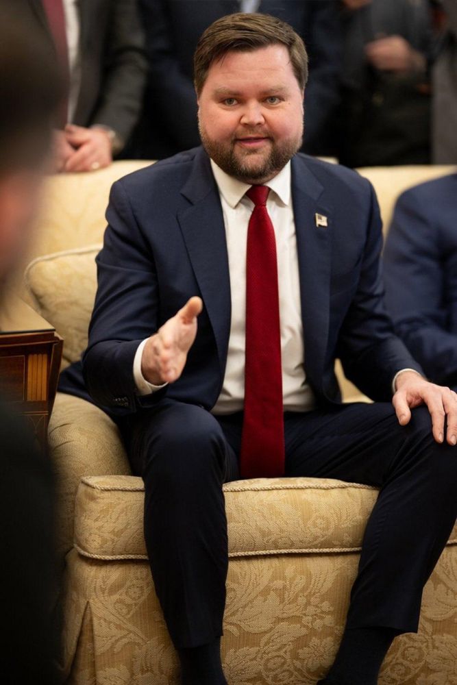 Photo of JD Vance sitting on a couch with his tie under his crotch.