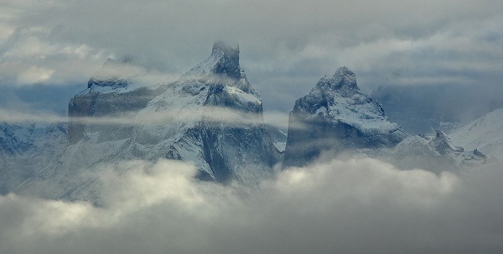 A moment of sublime beauty as heavy clouds slowly lift, unveiling the majesty that lurks behind. Torres del Paine National Park, Patagonia, Chile.