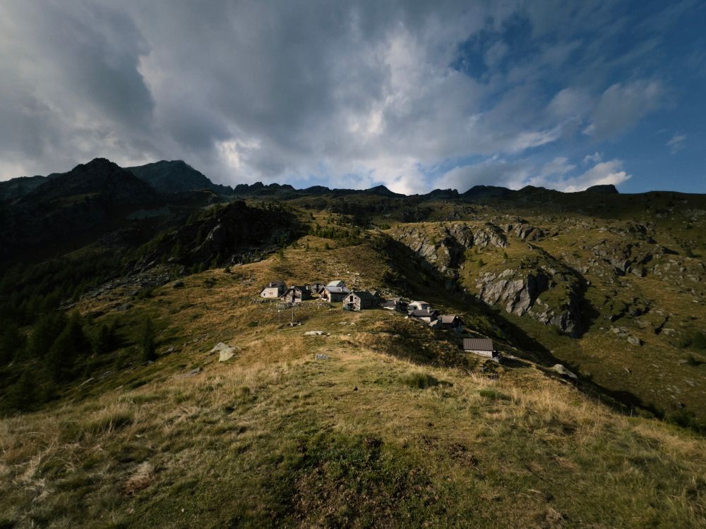 Summer alpine pasture village at sunset