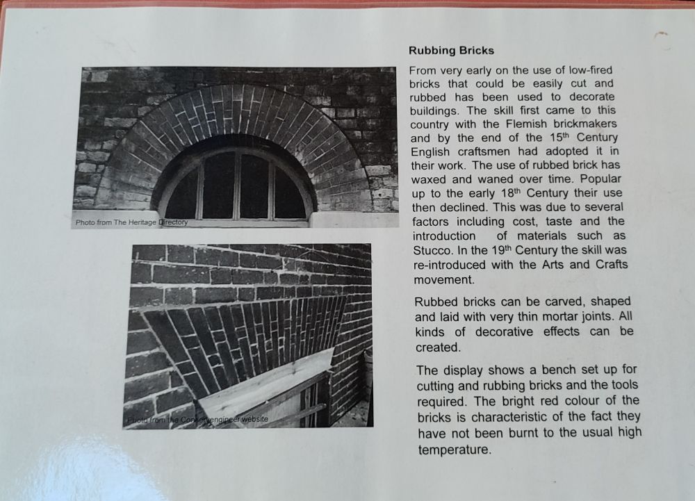 Accompanying text:

"Rubbing Bricks

From very early on the use of low-fired bricks that could be easily cut and rubbed has been used to decorate buildings. The skill first came to this country with the Flemish brickmakers and by the end of the 15th Century English craftsmen had adopted it in their work. The use of rubbed brick has waxed and waned over time. Popular up to the early 18th Century their use then declined. This was due to several factors including cost, taste and the introduction of materials such as Stucco. In the 19th Century the skill was re-introduced with the Arts and Crafts movement.

Rubbed bricks can be carved, shaped and laid with very thin mortar joints. All kinds of decorative effects can be created.

The display shows a bench set up for cutting and rubbing bricks and the tools required. The bright red colour of the bricks is characteristic of the fact they have not been burnt to the usual high temperature."