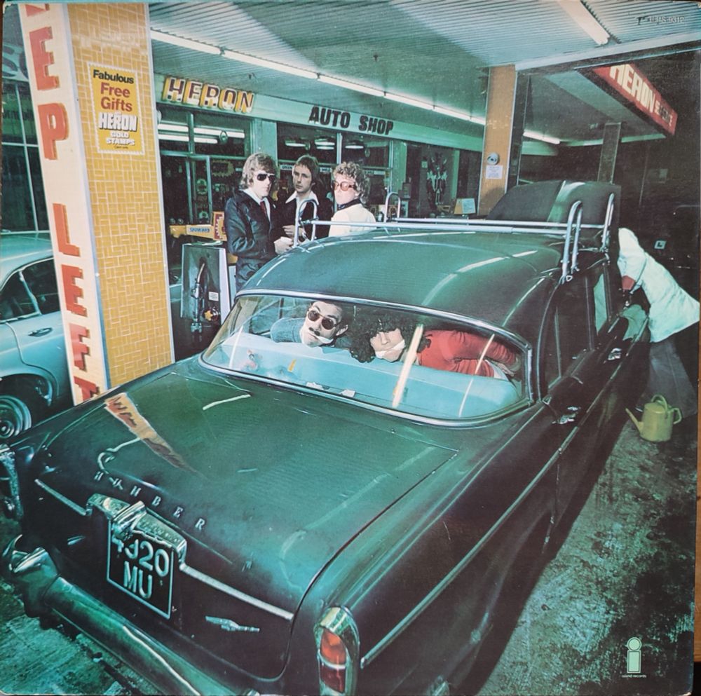 Back cover. The Mael bros still bound and gagged, this time looking very alarmed at you through the rear window of a big old car parked up in one of the bays of a petrol station or garage. An attendant is checking under the hood while three guys (presumably the rest of the band) hang around