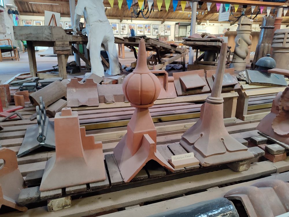 Rows of ceramic ridge tiles and finials displayed on the floor of the brick drying room at Swanwick Brickworks Museum 