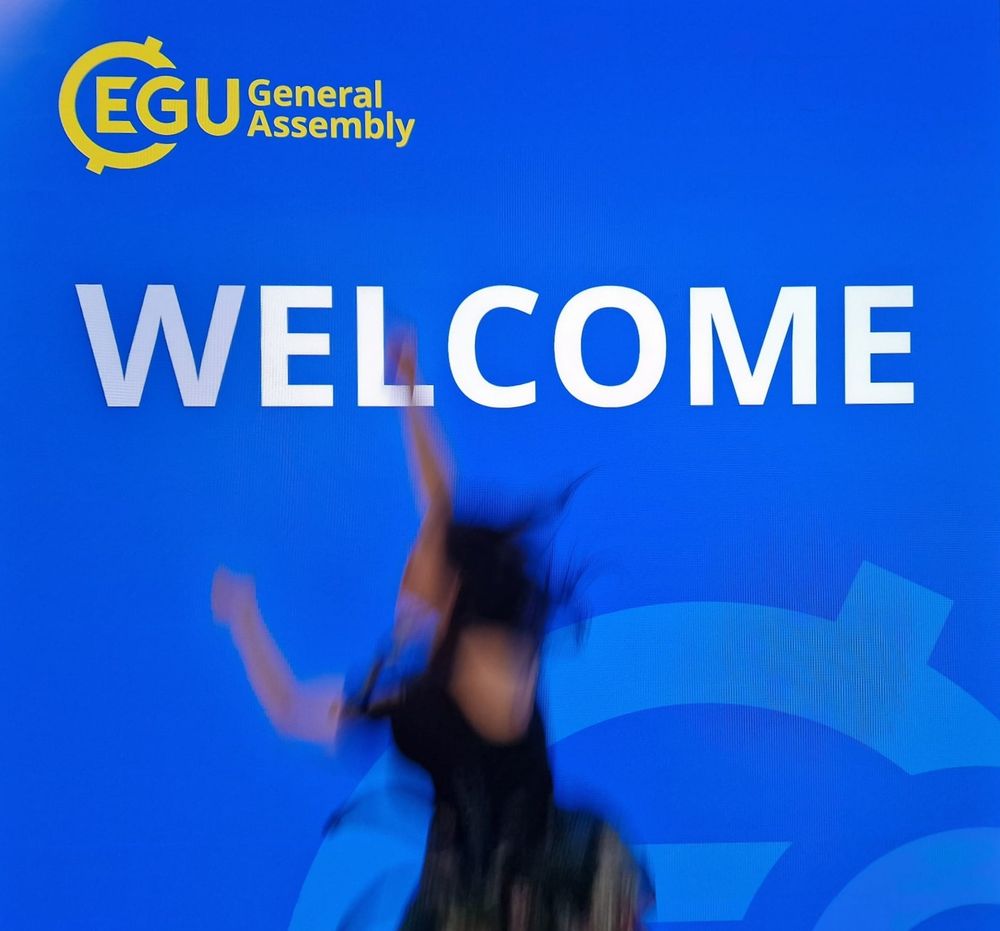 A blury picture of someone jumping in front of the EGU welcome sign