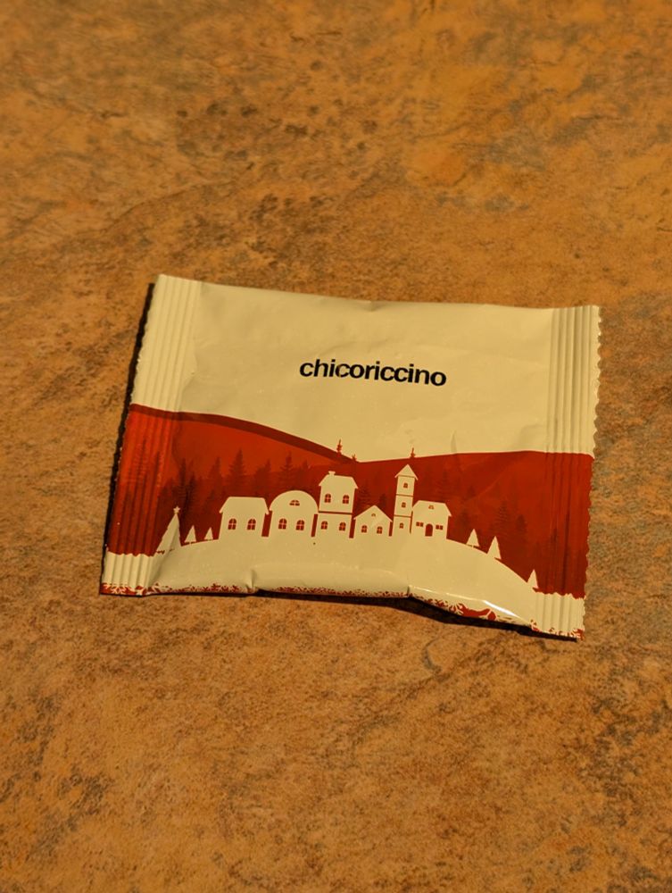 A red and white tea packet. Has a picture of the outlines of houses.