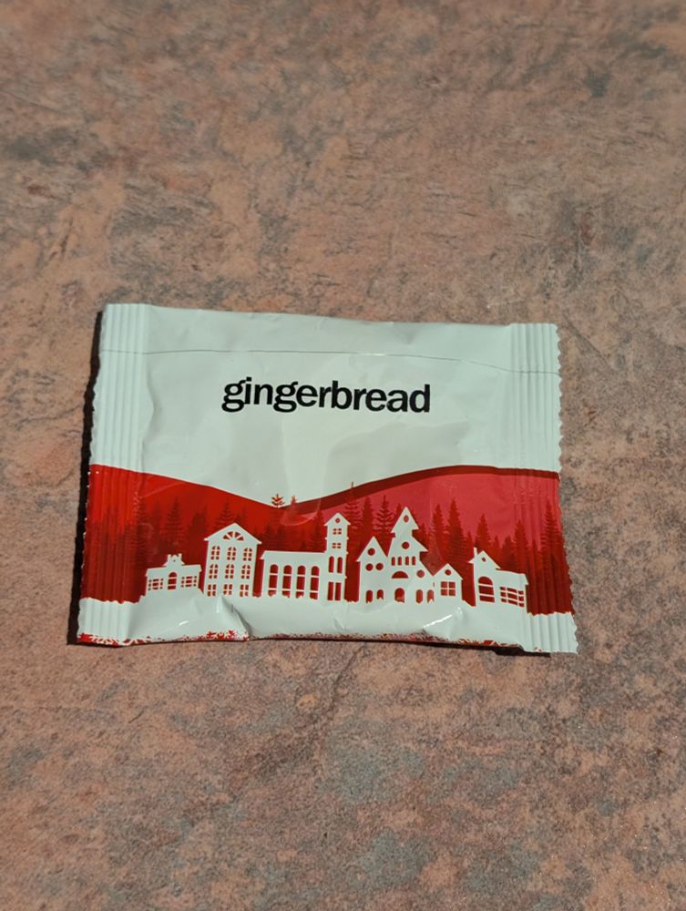 A tea packet with a white town profile in front of red hills
