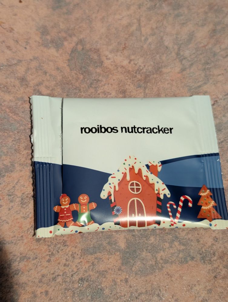 A tea packet with a gingerbread house and two gingerbread people on it