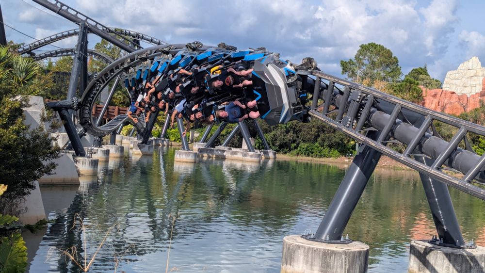 a car upside-down on the corkscrew of velicocoaster over the water, from a front angle