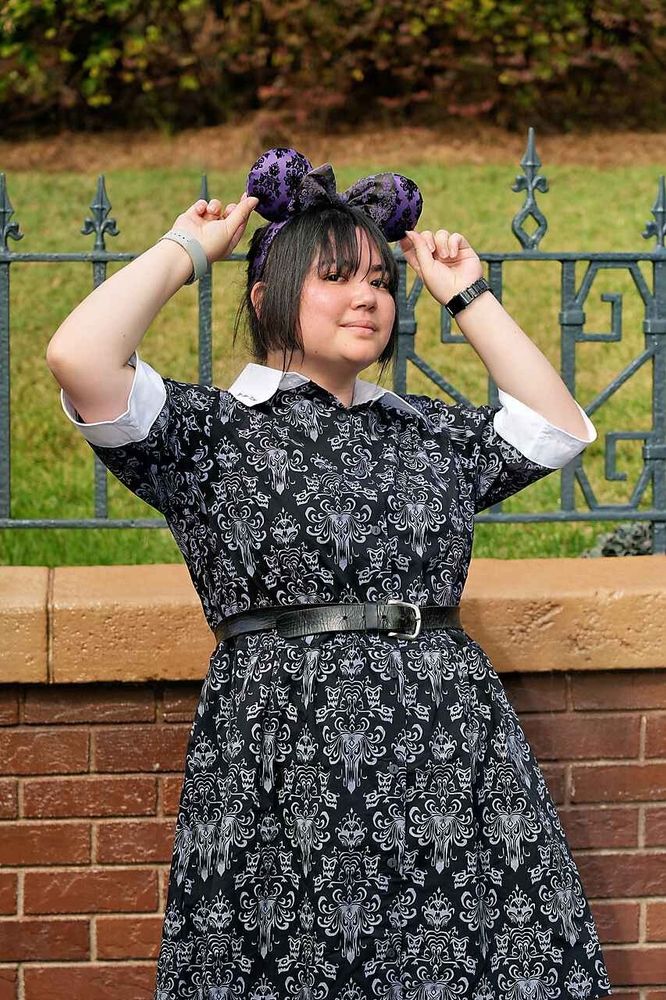 Victoria holding onto her Haunted Mansion wallpaper Mickey ears 
