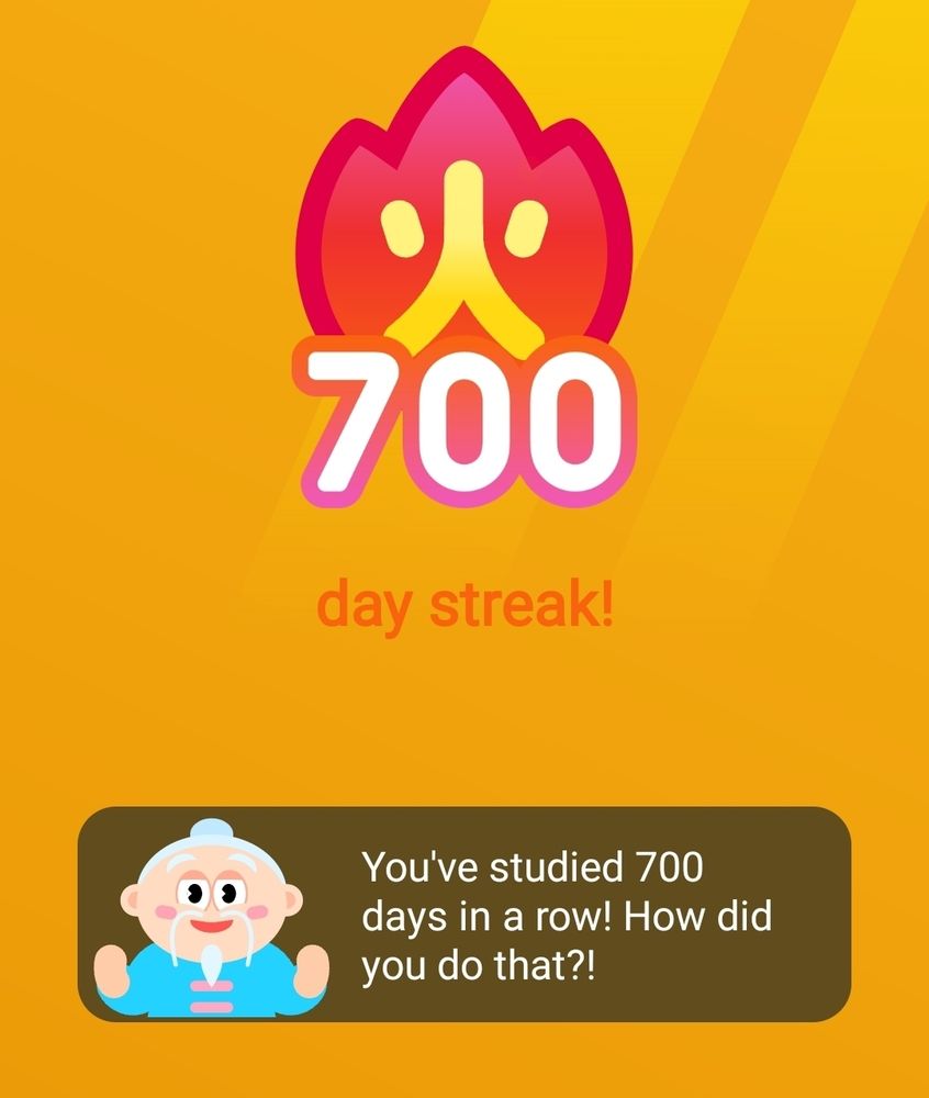 HelloChinese 700-day streak screenshot. Little Laoshi says, "You've studied 700 days in a row! How did you do that?!"
Yellow screen with the Chinese character for 'fire' alight over the number 700.