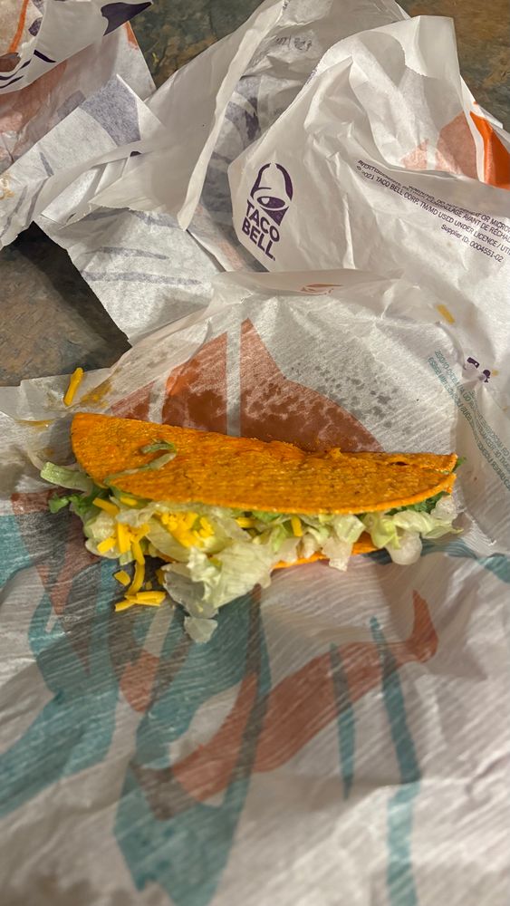 Bunch of Taco Bell wrappers and a dorito hard taco in the middle. It looks like a hot mess but is lukewarm at best. 