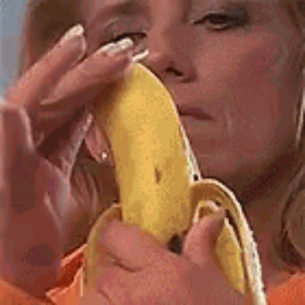 a woman is eating a banana with her eyes closed and her mouth open .