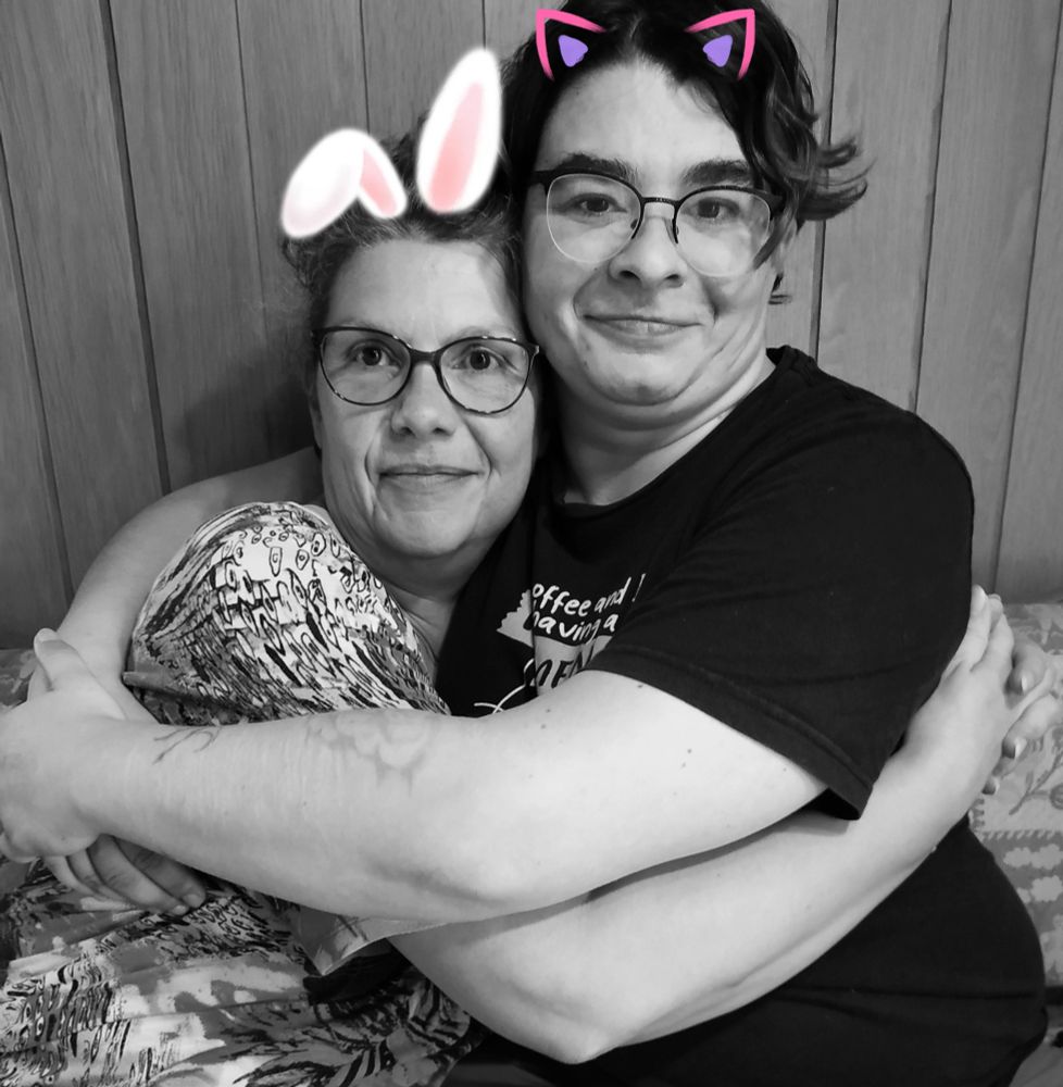 Foto von Herzwurm und mir in s/w mit bunten Filter Öhrchen, lachend und sich unarmend. 