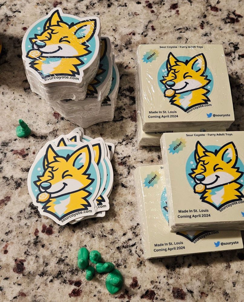 stacks of stickers containing the sour coyote mascot: a yellow coyote with teal accents holding a lemon slice