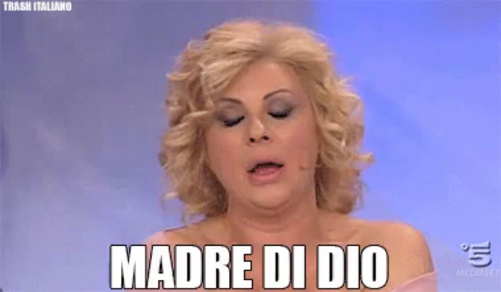 a woman with a ring on her finger wipes her face with her hand and says " madre di dio "