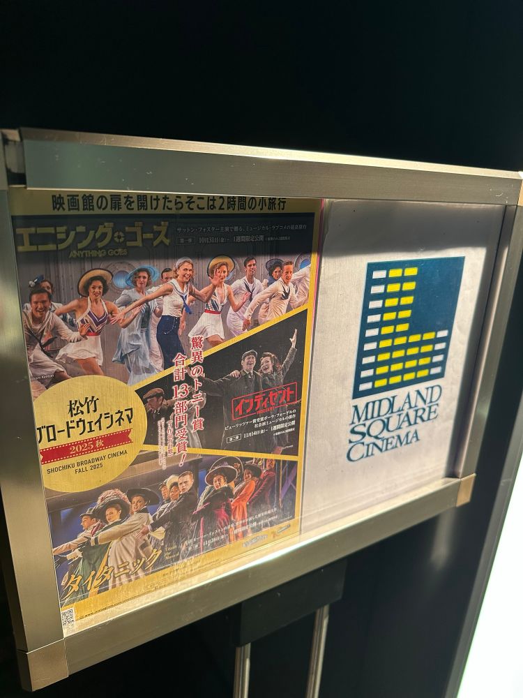 映画館のシアター入口横に「松竹ブロードウェイシネマ」のポスターが掲示されている。