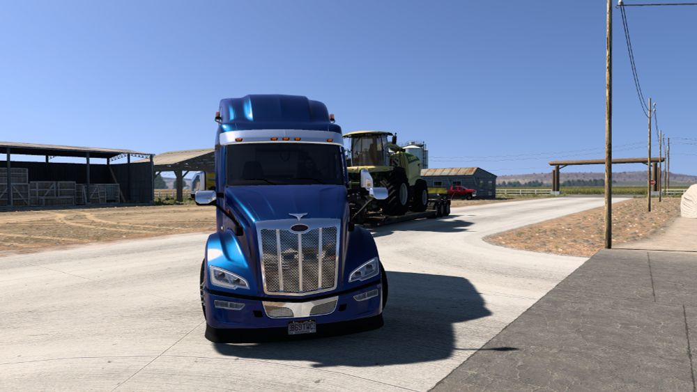 Screenshot from American Truck Simulator showing my Peterbilt 579 Next Gen arriving at a Ontario, OR farm with a Krone forage harvester.
