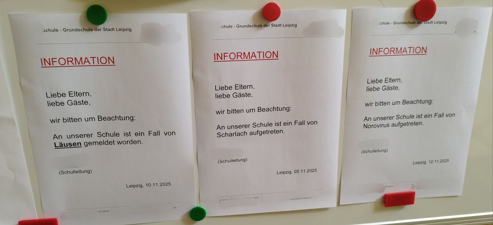 Eine Magnettafel im Treppenhaus einer Grundschule. Dort hängen 3 Informationsschreiben mit roten und grünen Magneten fixiert, über Fälle von Scharlach, Läuse und Norovirus, welche aktuell in der Grundschule auftreten.