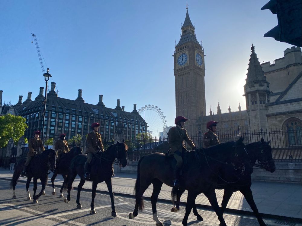 Horses being ridden in the quiet streets of Westminster with Big Ben in the background.
