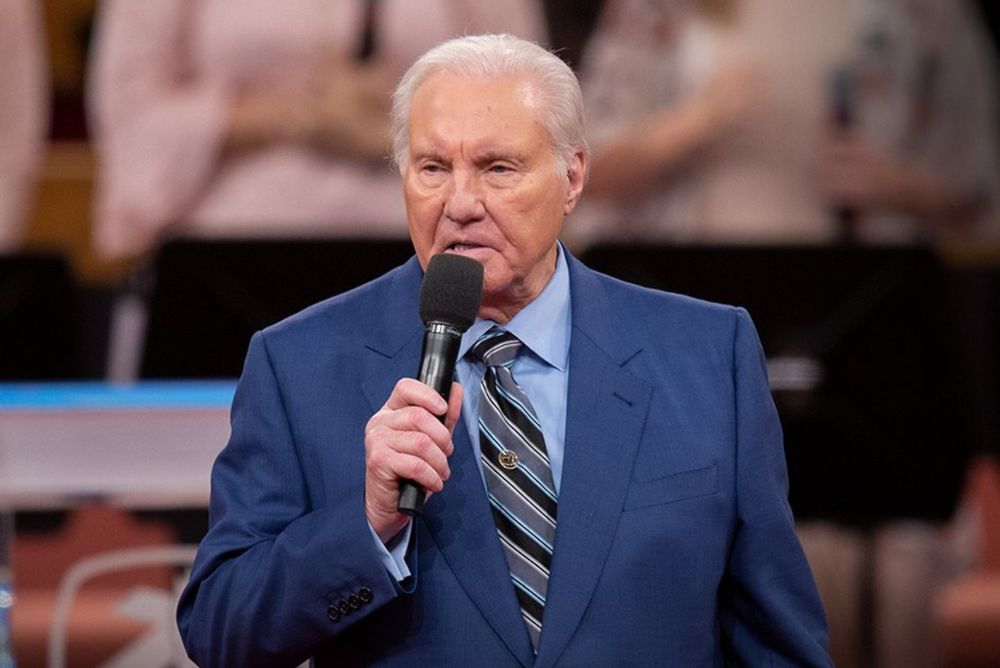 A photo of televangelist Jimmy Swaggart in a blue suit, holding a mic