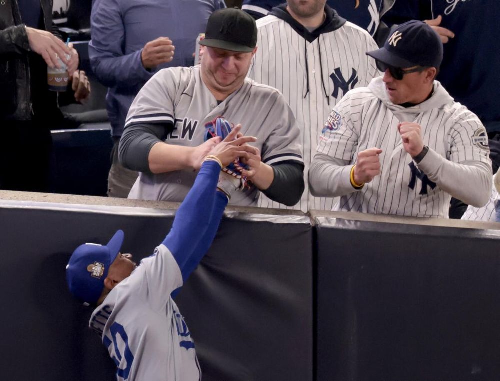 A fan grabs Mookie Betts' glove during a game