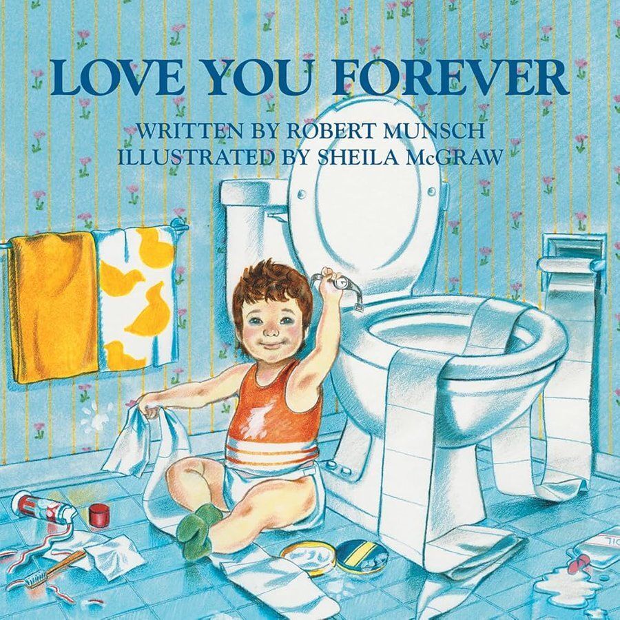 A young child in a diaper and orange tank top sits on a bathroom floor, surrounded by scattered toilet paper, towels, and toiletries. The child is reaching up toward an open toilet with one hand and holding a piece of paper with the other. The bathroom has blue walls with a floral pattern, a yellow towel with duck designs on a rack, and a sink in the background. The book title "LOVE YOU FOREVER" by Robert Munsch, illustrated by Sheila McGraw, is displayed at the top.