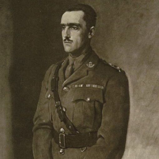 Black-and-white portrait of a man with dark hair and a thin mustache, facing left with a serious expression, wearing a military uniform jacket with epaulettes, crown insignia, ribbon bars on the chest, a tie, cross-body strap, belt, and three vertical stripes on the lower sleeve, holding a swagger stick in clasped hands, against a plain background.