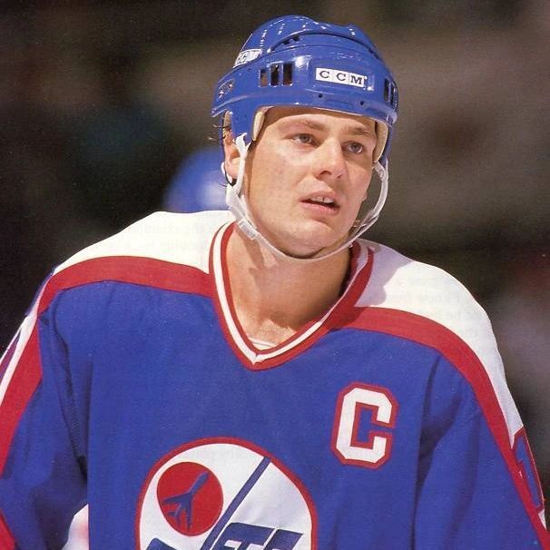 A hockey player wearing a blue jersey with red and white accents, featuring the 