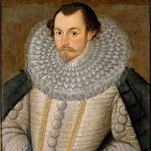 A formal portrait of a man from the Renaissance period, dressed in elaborate clothing with a large, ornate ruffled collar, a richly embroidered doublet with gold buttons, and dark sleeves. He holds a pair of gloves in one hand, exuding an air of nobility and status.