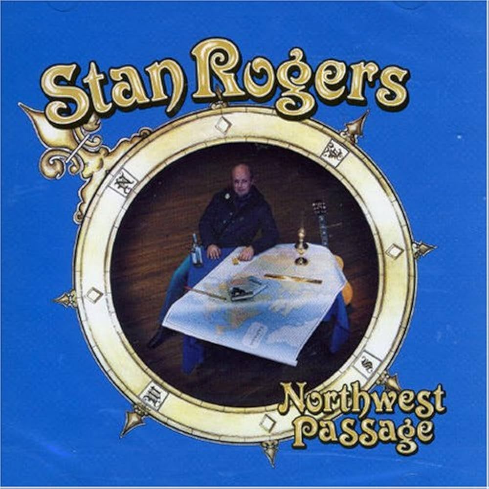 The image is the cover of the album Northwest Passage by Stan Rogers. The background is a solid blue, with the album title and artist name in a decorative, gold-colored font. "Stan Rogers" is written at the top, and "Northwest Passage" at the bottom. The central image is framed in a circular, nautical-themed border resembling a compass rose, with fleur-de-lis and other ornamental elements. Inside the circle, Stan Rogers is seated at a table covered with a map, holding a bottle, with a guitar leaning nearby. The scene evokes a sense of exploration and folk storytelling, fitting the album's 1981 release and its focus on Canadian maritime themes.