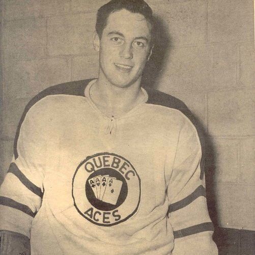 The photo shows Jean Béliveau wearing a Quebec Aces hockey jersey, featuring a circular logo with the text 