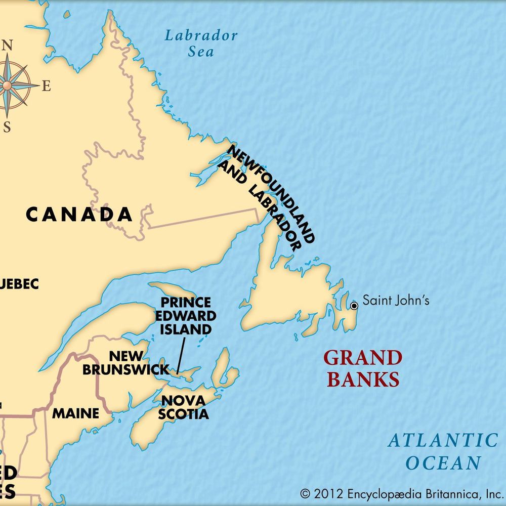 A simple political map of Atlantic Canada and surrounding areas. It shows the eastern provinces of Canada: Quebec (large area on the left), New Brunswick, Prince Edward Island, Nova Scotia, and Newfoundland and Labrador (island on the right with Saint John's marked). Part of the United States is visible at bottom left with Maine, Lake Ontario, and Ottawa marked. The Grand Banks fishing area is labeled in red off the southeast coast of Newfoundland. The Atlantic Ocean fills the right side, Labrador Sea at top right. A compass rose points north. Light beige land, light blue water, black text labels, copyright 2012 Encyclopædia Britannica, Inc. at bottom right.