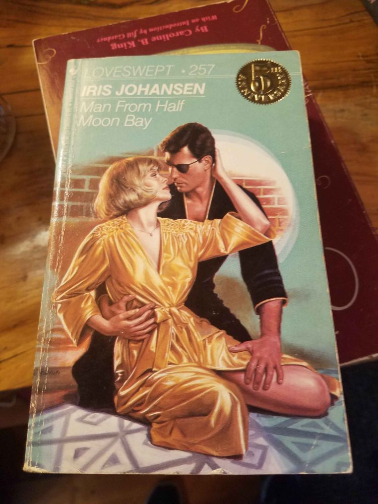 The cover for Loveswept 257 by Iris Johansen, "Man from Half Moon Bay." A woman in a golden silk robe is held by a man in black with an eyepatch.
