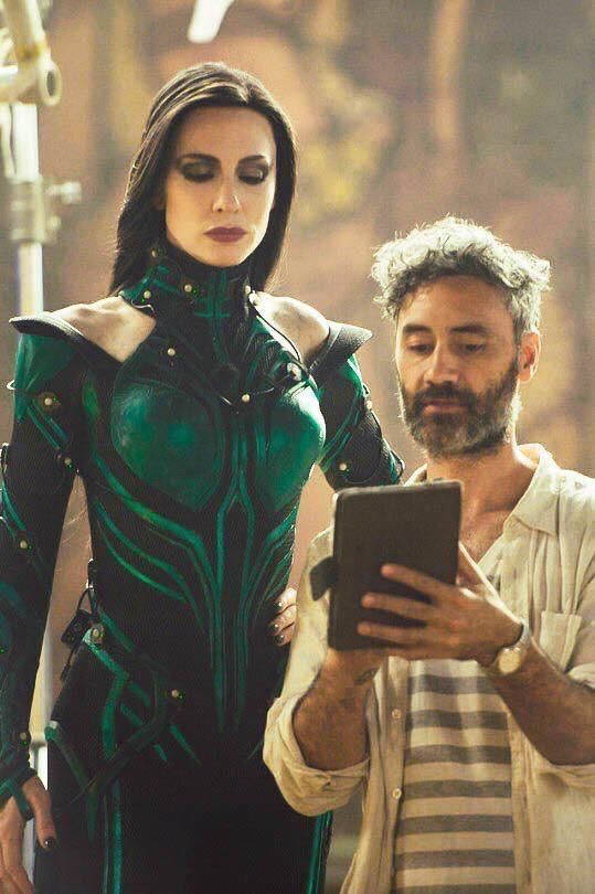 tall green marvel lady on set looking at tablet held up by scruffy director(?) guy 