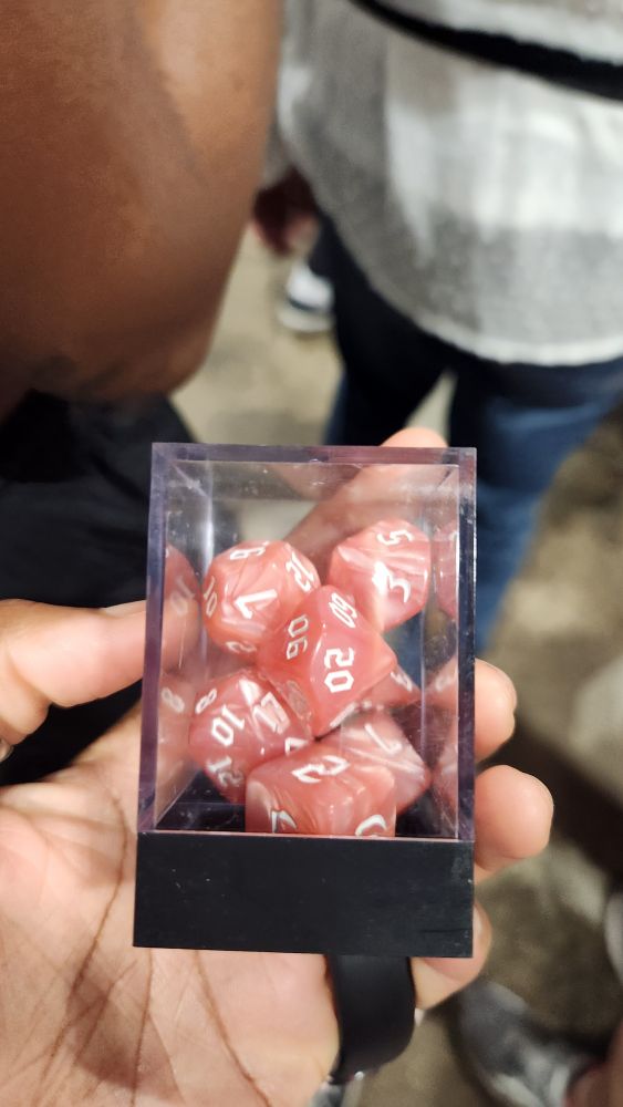 peach coloured d&d die with white numbers.