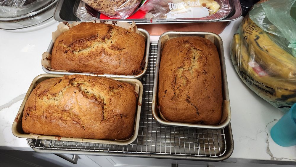three banana bread loaves sitting on a counter.