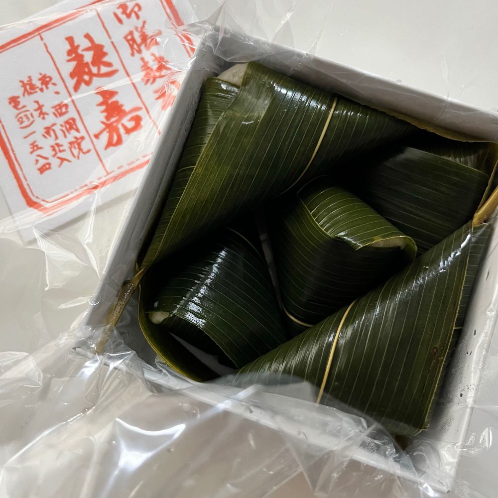 京都麩嘉の小箱の蓋を開けたところ
艶艶とした笹にくるまれた端正な佇まいの麩饅頭５個が詰まっている