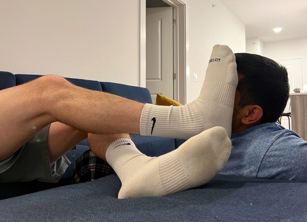 Guy who I wish was me with another man’s feet in white Nike socks pressed on his face  
