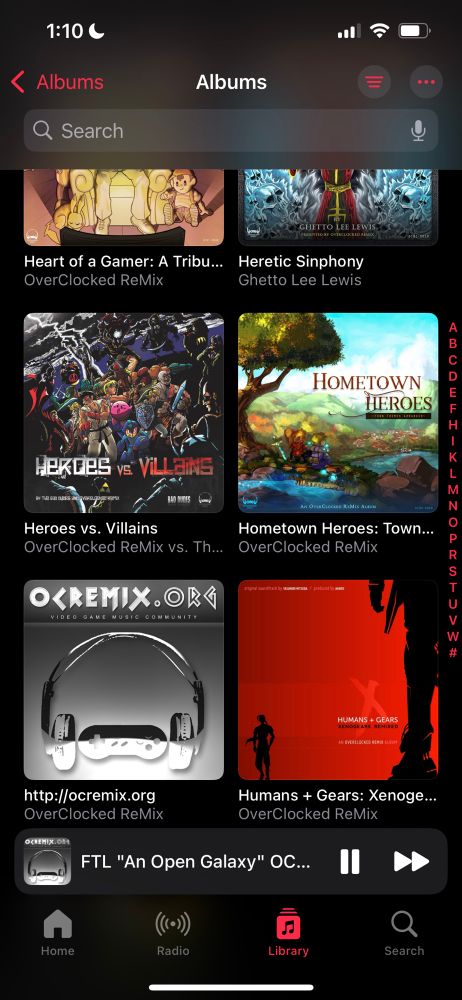 iPhone screen capture showing Apple Music in album view mode, with several OverClocked ReMix video game music arrangement albums including, Heart of a Gamer, Heretic Symphony, Heroes vs. Villains, Hometown Heroes, http://ocremix.org (individual pieces), and Humans + Gears. Current song playing: FTL “An Open Galaxy” OC ReMix