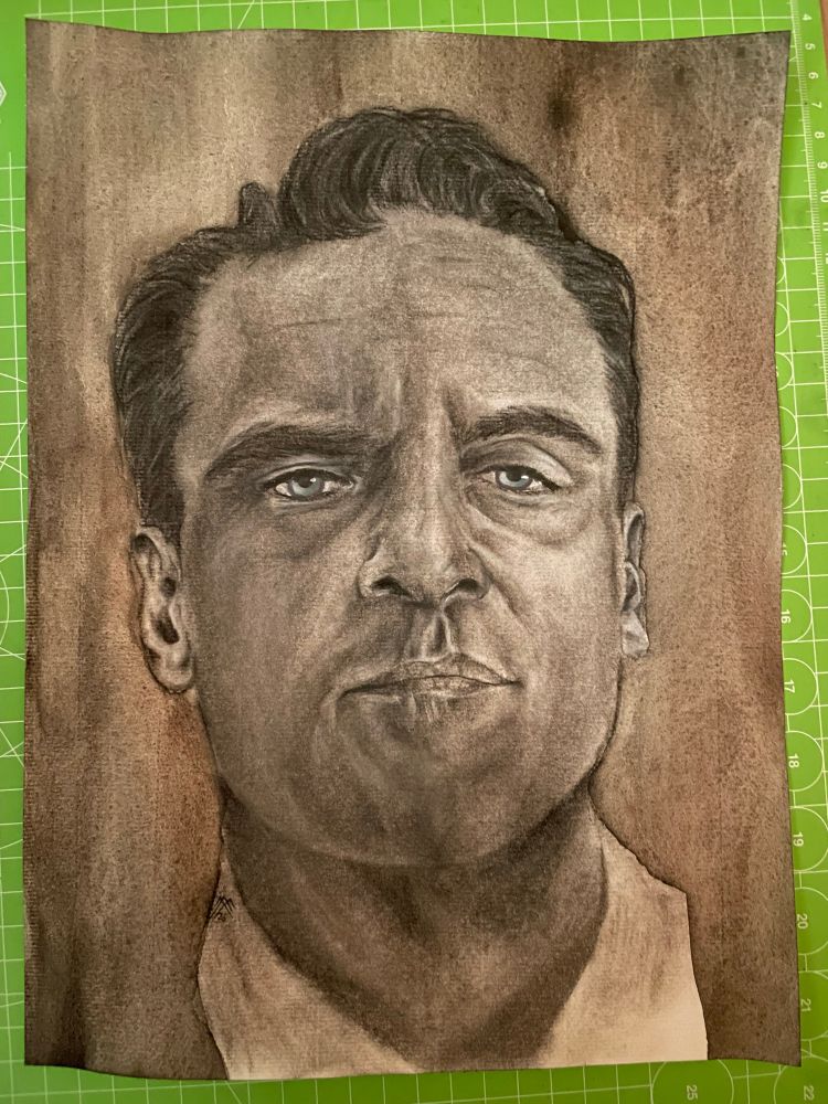 The actor Joaquin Phoenix as a charcoal portrait. Front view with Blue eyes on liquid charoal backround