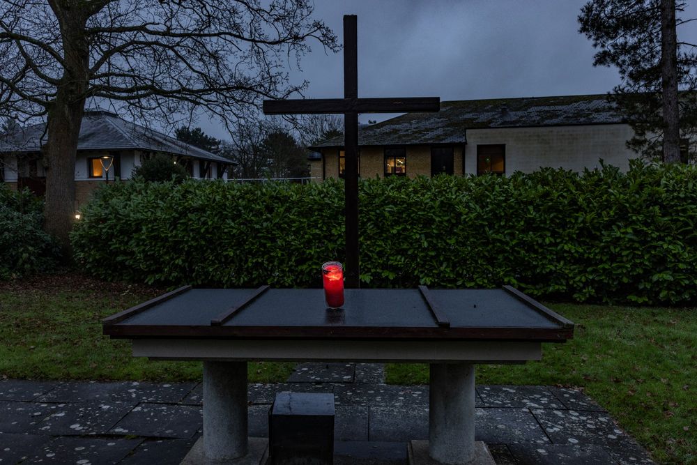 The Peace Light candle glows red in the twilight on the altar of the out-door chapel at Gilwell Park, UK.