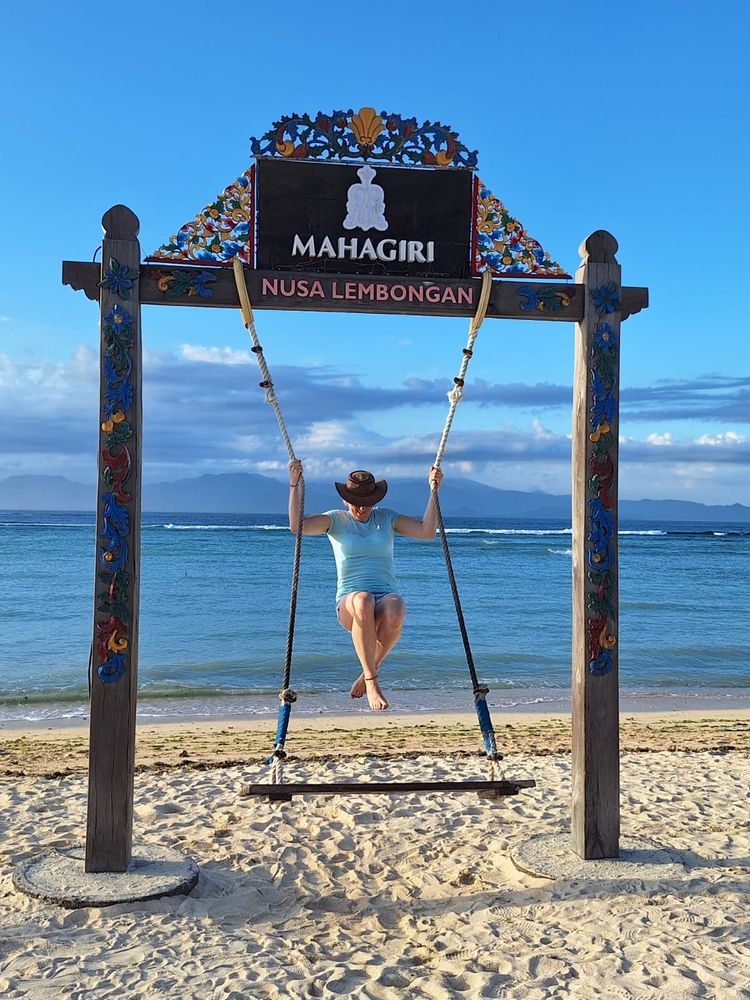 A woman on a swing on the beach