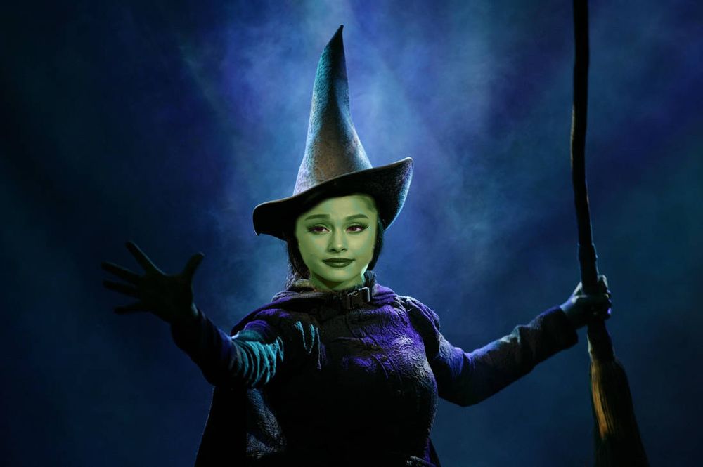 Edited photo of Ariana grande as Elphaba in Wicked, the green witch with a cunty pointy hat and a broomstick 
