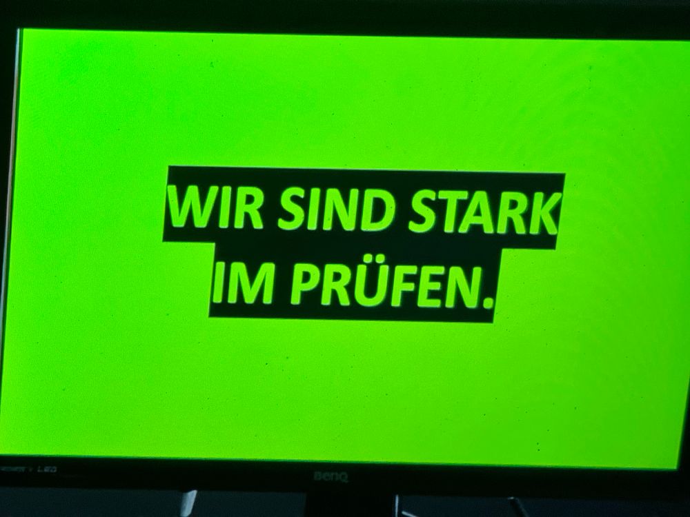 Grünes Plakat mit der Aufschrift; Wir sind stark im Prüfen 